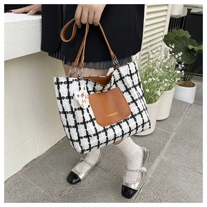 Détail du sac cabas en tweed à carreaux avec poche en cuir marron et breloque mignonne