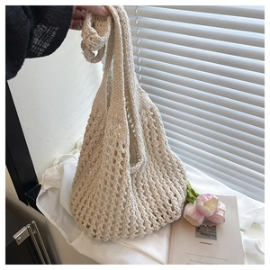 Close-up of beige crochet straw tote bag with diamond mesh pattern and soft cotton texture
