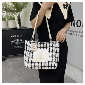 Detail of plaid tweed tote bag with front pocket and cute cartoon tiger charm