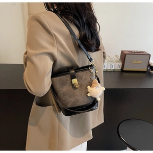 Détail du sac seau rétro avec fermoir doré et charme nain en peluche en décor vintage