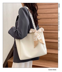 Detail of white tote bag with woven shoulder strap and cherry pattern silk scarf decor