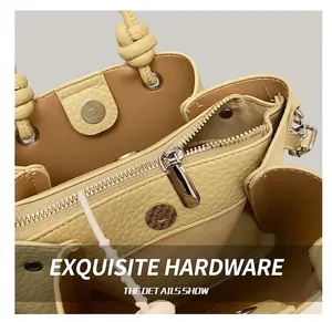 Detail view of lychee pattern leather handbag with metal zipper and magnetic buckle