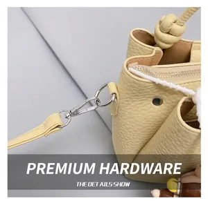 Close-up of premium metal hook and lychee texture on yellow bucket bag side