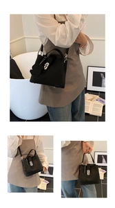 Détail du sac seau noir en cuir avec fermoir rotatif argenté et breloque chien