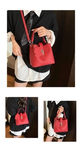 Détails du sac seau rouge vif à texture litchi avec un charmant pendentif chien