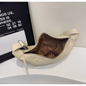 Detail der cremefarbenen Tasche mit braunem Streifenfutter und Innentaschenstruktur