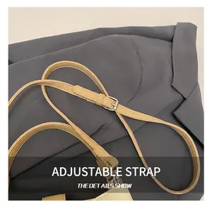 Détail de la bandoulière réglable en similicuir avec boucle argentée sur sac marron