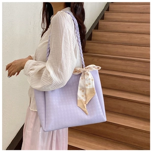 Detail of lavender tote bag with houndstooth embossing and stylish silk scarf accessory
