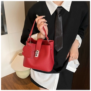 Détail du sac seau rouge en cuir grainé avec breloque en forme de petit chien