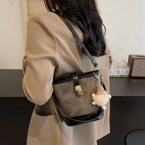 Sac seau vintage à motif marbre avec fermoir doré et charme peluche sur mannequin