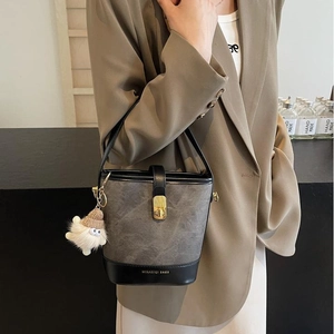 Sac seau contrasté gris et noir avec fermoir doré et accessoire en peluche doux