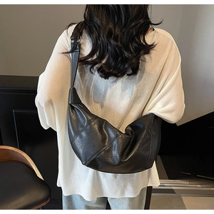 Rückansicht eines Modells mit einer großen schwarzen Hobo-Tasche aus strukturiertem Leder