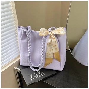 Detail of lavender tote bag with textured surface and cherry patterned silk scarf knot