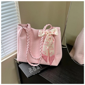 Detail of pink textured tote bag with thick woven handle and decorative floral silk scarf