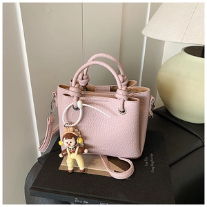 Pink lychee texture mini tote bag with knotted handles and cute cartoon doll charm