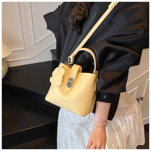 Détail du sac seau jaune clair en cuir grainé avec un pendentif chien mignon