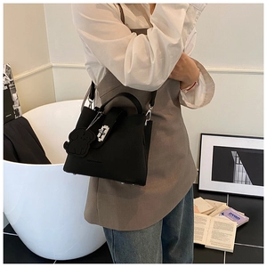 Détail du sac seau en cuir grainé noir avec fermoir argenté et bijou de sac chien
