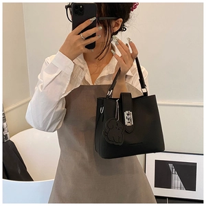 Détail du sac seau noir en cuir grainé avec fermoir argenté et bijou de sac