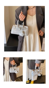 Detail of light blue glossy patent leather handbag with metal lock and heart charm