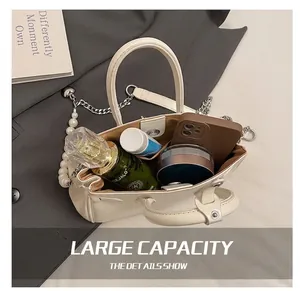 Detail view of large capacity tote bag interior with pearl chain strap and daily items
