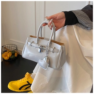Detail view of glossy light blue handbag with silver padlock and heart-shaped pendant