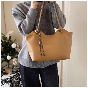 Brown large capacity tote bag with wavy rim and knot shoulder strap detail