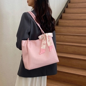 Pink tote bag with houndstooth texture and silk scarf bow shown on model in home setting