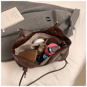 Detail of spacious interior in coffee brown tote bag showing daily essentials storage