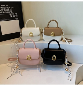 Detail view of stylish square handbags in four colors featuring elegant gold clasps