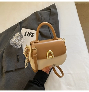 Close-up of saddle bag with gold arch buckle and decorative silk scarf detail