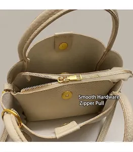 Close-up of beige leather tote interior with golden zipper pocket and magnetic closure