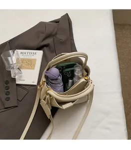 Detail of off-white bucket bag interior showing capacity for phone and cosmetics