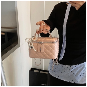 Roze gewatteerde vanity bag met metalen ketting en een hanger van parelmoer strik
