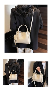 Close-up of beige lychee leather tote with gold hardware and a cute dog-shaped charm