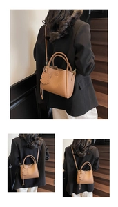 Brown lychee leather bucket bag with puppy charm detail and adjustable shoulder strap