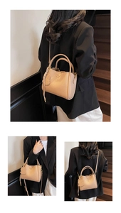 Detail of beige litchi leather bucket bag featuring cute bear charm and adjustable strap