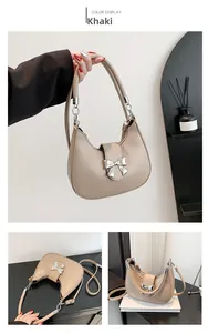 Détail du sac bandoulière croissant kaki avec nœud argenté et texture en cuir mat
