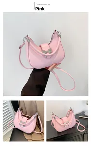 Détail du sac sous le bras en forme de croissant rose avec nœud argenté et bandoulière