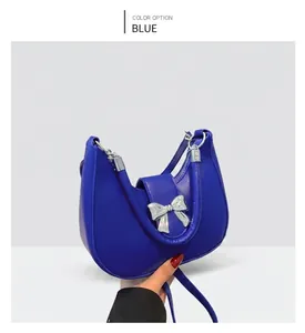 Détail du sac hobo croissant bleu en cuir brillant avec un nœud en métal argenté