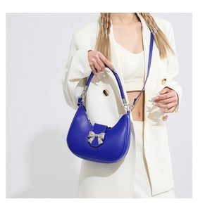 Détail du sac demi-lune bleu Klein avec une boucle décorative en forme de nœud