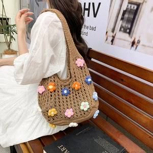 Handmade crochet straw tote bag with colorful 3D floral accents for beach vacations