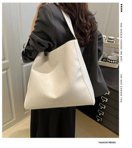 Détail du grand sac porté épaule blanc texturé présenté avec un look citadin élégant