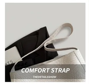 Détail de la bandoulière large et confortable sur un sac blanc en similicuir texturé