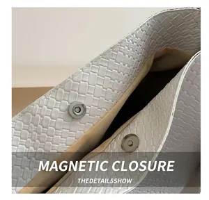 Détail du fermoir magnétique sur le grand sac seau blanc à texture tressée