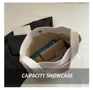 Vue de dessus de l'intérieur du grand sac cabas tissé montrant sa capacité et son fermoir