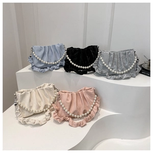 Detailed display of colorful satin pleated bags with elegant pearl chain handles