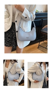Detail view of a light blue hobo bag featuring a metal bow and adjustable shoulder strap