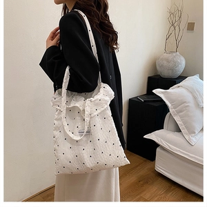 Détail du sac à bandoulière blanc à volants avec motif floral et étiquette tendance