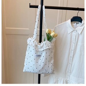 Détail d'un cabas en résille à fleurs avec volants et étiquette de mode textile