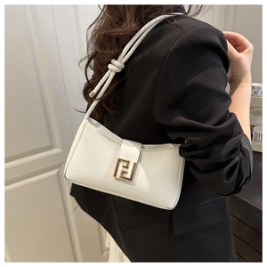 Detail of white leather baguette bag with gold logo buckle on black blazer